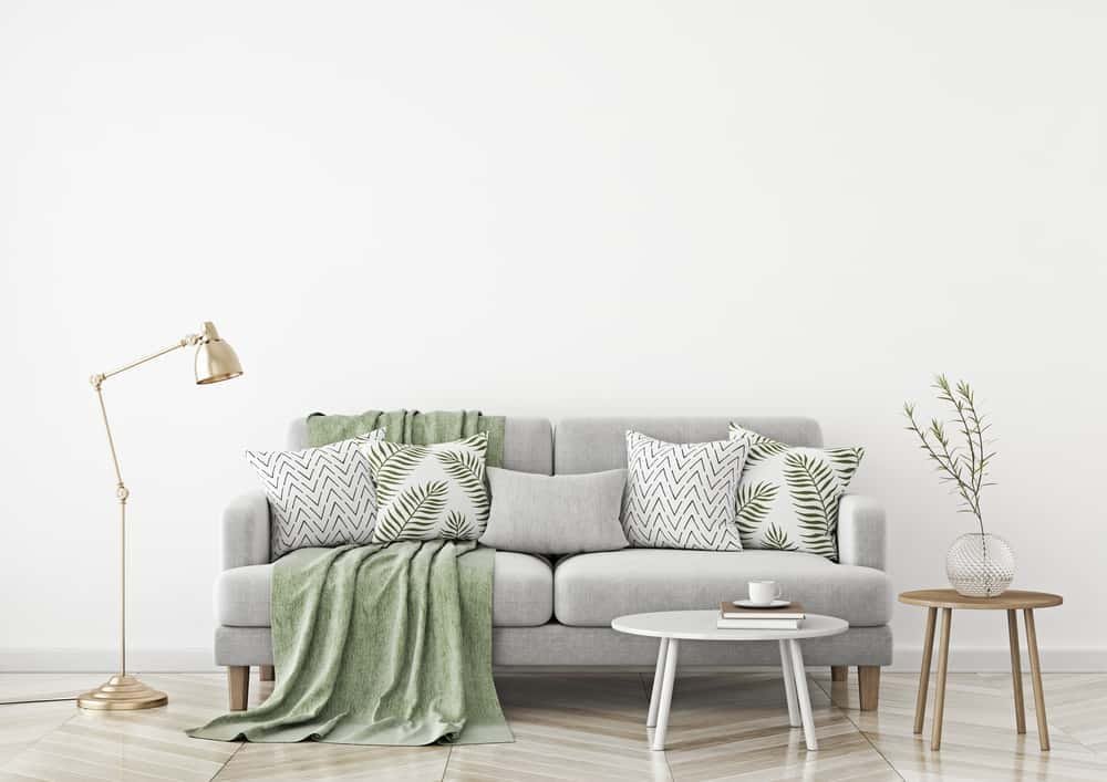 A neutral sofa layered with woven and patterned cushions in several complementary scales
